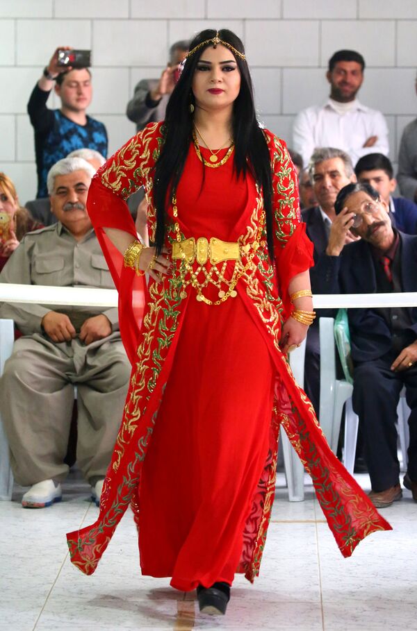 A Syrian-Kurdish model hits the catwalk in a bright red full-length gown, with a red overcoat heavily embroidered in gold. - Sputnik International