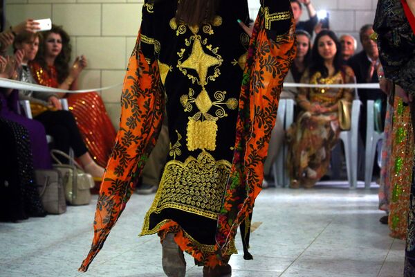 A Syrian-Kurdish model wears traditional Kurdish attire during a fashion show in the northeastern Syrian city of Qamishli. - Sputnik International