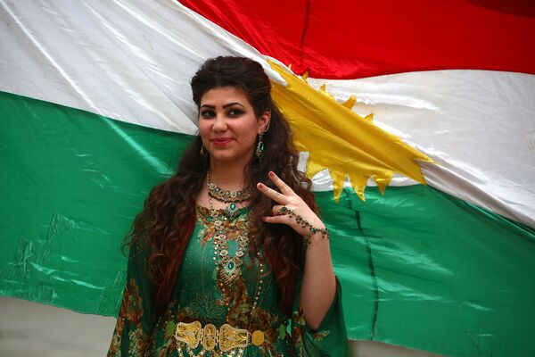 A Syrian-Kurdish model poses in front of Kurdish flag. - Sputnik International