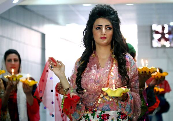 Syrian-Kurdish model wears a pink floral patterned long gown with daggling gold earrings. - Sputnik International
