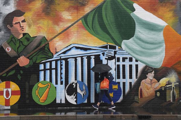 A woman walks past a political mural in the Falls Road area of west Belfast, Northern Ireland, February 28, 2017. A woman walks past a political mural in the Falls Road area of west Belfast, Northern Ireland, February 28, 2017. - Sputnik International