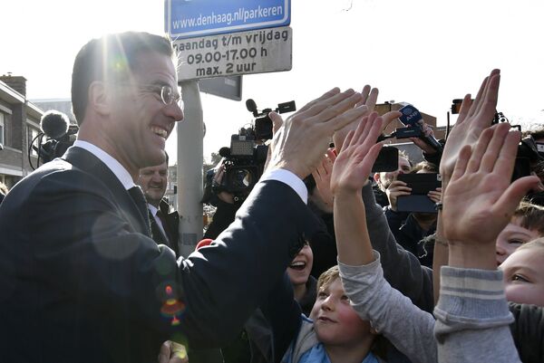 Dutch Prime Minister Mark Rutte gives 'high five' to children after casting his vote for the Dutch general election in The Hague, Netherlands, Wednesday, March 15, 2017 - Sputnik International