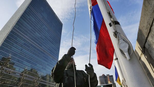 A United Nations security officer raises the Russian flag outside U.N. headquarters, Tuesday morning, Feb. 21, 2017 - Sputnik International