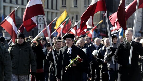 People hold flags, as they participate in the annual procession commemorating the Latvian Waffen-SS (Schutzstaffel) unit, also known as the Legionnaires, in Riga, Latvia March 16, 2017 - Sputnik International