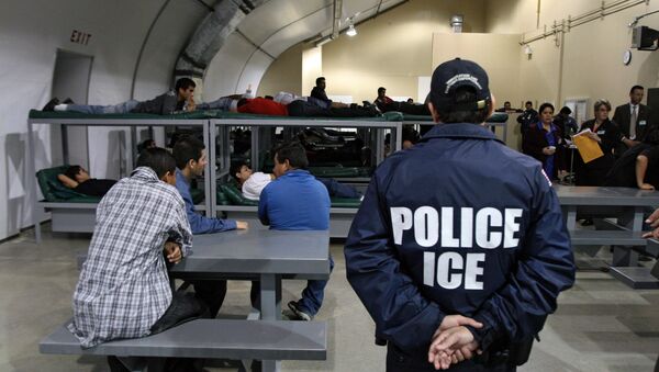 An Immigration and Customs Enforcement (ICE) officer guards a group of 116 Salvadorean immigrants that wait to be deported,at Willacy Detention facility in Raymondville, Texas on 18 December 2008 - Sputnik International
