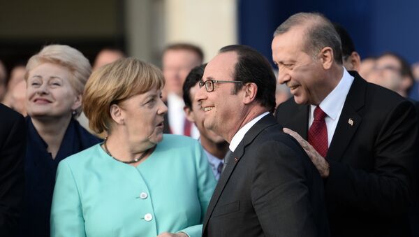 (L-R) German Chancellor Angela Merkel, French President Francois Hollande and Turkish President Recep Tayyip Erdogan share a smile as they attend the fly-past of NATO countries' jetfighters at the entrance of the National Stadium, the venue of the starting NATO summit, on July 8, 2016 - Sputnik International
