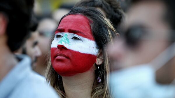 A Lebanese woman, with her face painted in the colours of Lebanon's national flag, takes part in a demonstration in downtown Beirut on August 8, 2015 - Sputnik International