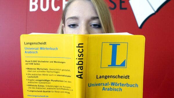 A young woman holds an universal dictionary Arabic as she sits in front of a poster at the International Bookfair in Frankfurt , Germany (File) - Sputnik International