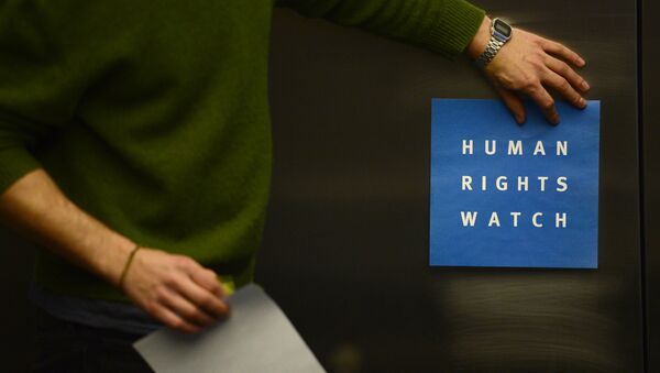 A man puts a logo of US-based rights group Human Rights Watch on the wall as he prepares the room before their press conference to release their annual World report on January 21, 2014 in Berlin - Sputnik International