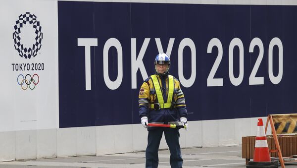 A security guard stands in front of an official logo of the 2020 Tokyo Olympic Games on the safety wall at a construction site in Tokyo's Nihonbashi shopping and office district, Monday, Feb. 6, 2017 - Sputnik International