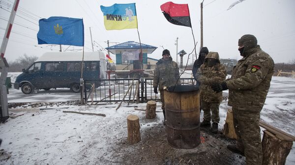 Activists warm themselves by a fire in a camp at Kryvyi Torets station as they take part in a rail blockade that has halted coal supplies in the village of Shcherbivka in the Donetsk Region, 14 February 2017.  - Sputnik International