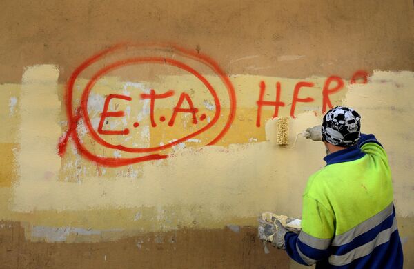 A municipal worker paints over graffiti reading ETA, The People Are With You in the Basque town of Guernica, Spain. - Sputnik International