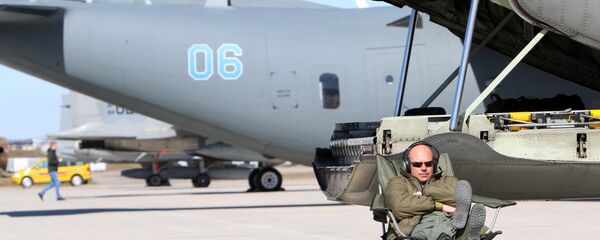 A technician sits near Sweden's C130 Hercules transport aircraft during the Lithuanian - NATO air force exercise at the air force base near Siauliai Zuokniai, Lithunaia on April 1, 2014 - Sputnik International