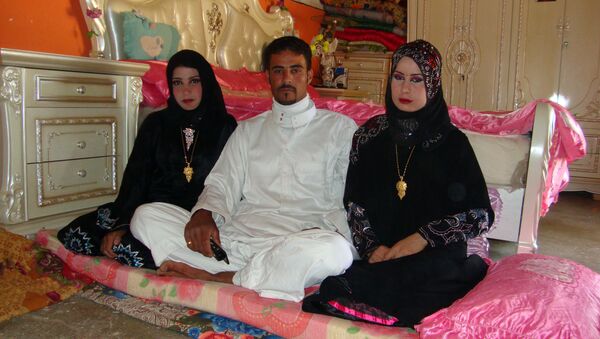 Abdul Rahman al-Obeidi, a 22 year-old Iraqi farmer, sits between his two new wives on April 25, 2012 in Samarra - Sputnik International