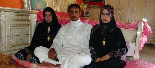 Abdul Rahman al-Obeidi, a 22 year-old Iraqi farmer, sits between his two new wives on April 25, 2012 in Samarra Abdul Rahman al-Obeidi, a 22 year-old Iraqi farmer, sits between his two new wives on April 25, 2012 in Samarra - Sputnik International