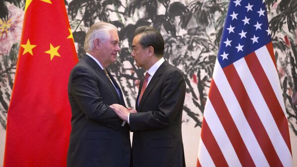 U.S. Secretary of State Rex Tillerson, left, and Chinese Foreign Minister Wang Yi stare at each other as they shake hands at the end of a joint press conference following their meeting at the Diaoyutai State Guesthouse in Beijing, China, Saturday, March 18, 2017 - Sputnik International