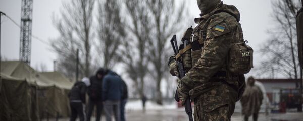A Ukrainian serviceman patrols at the humanitarian aid center in Avdiivka, Ukraine, Saturday, Feb. 4, 2017 - Sputnik International