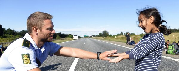 Danish policeman plays with a migrant girl (file) Danish policeman plays with a migrant girl (file) - Sputnik International