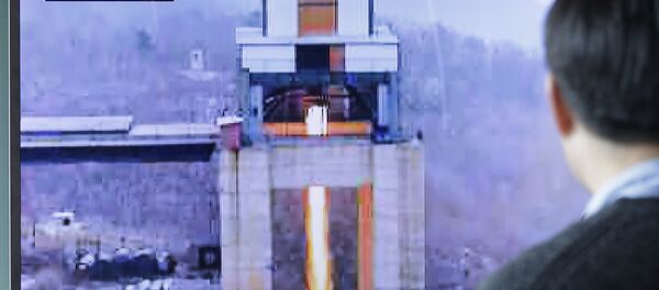 A man watches a TV news program showing an image that North Korea's Rodong Sinmun newspaper reports of a ground test of a new type of high-thrust rocket engine A man watches a TV news program showing an image that North Korea's Rodong Sinmun newspaper reports of a ground test of a new type of high-thrust rocket engine - Sputnik International