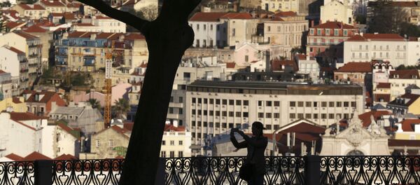 A woman taking pictures from a public garden is silhouetted against the buildings in Lisbon's old town center Wednesday evening, March 15, 2017. A woman taking pictures from a public garden is silhouetted against the buildings in Lisbon's old town center Wednesday evening, March 15, 2017. - Sputnik International