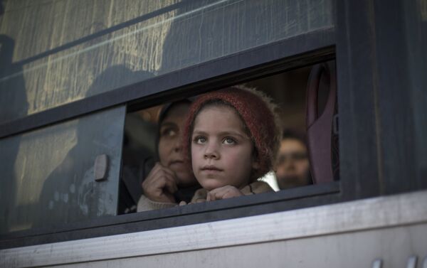 A displaced Iraqi girl, fleeing fighting between Iraqi security forces and Islamic State militants, looks out from a bus as she arrives with her family at the Hassan Sham camp, east of Mosul, Iraq, Tuesday, March 21, 2017. - Sputnik International