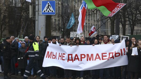 People hold a banner at a protest against increased tariffs for communal services and new taxes, including the tax for those who are not in full-time employment, in Minsk, Belarus March 15, 2017. The banner reads, We are not spongers! - Sputnik International
