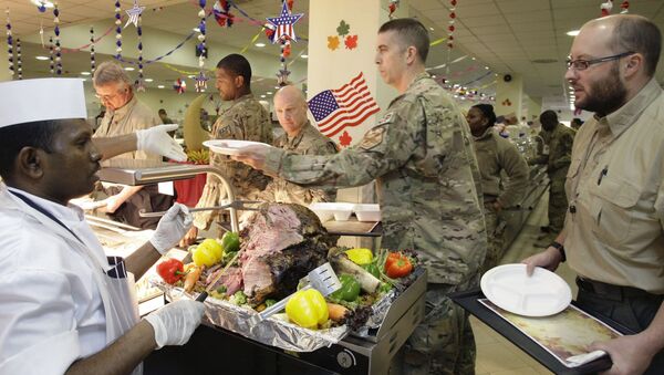 A dining facility worker, left, serves meat to soldiers and civilians for their Thanksgiving meal at the US-led coalition base in Kabul, Afghanistan, Thursday, November 22, 2012. - Sputnik International