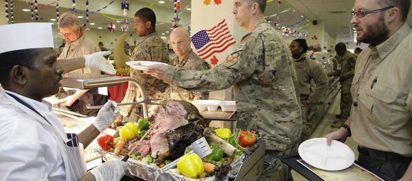 A dining facility worker, left, serves meat to soldiers and civilians for their Thanksgiving meal at the US-led coalition base in Kabul, Afghanistan, Thursday, November 22, 2012. - Sputnik International