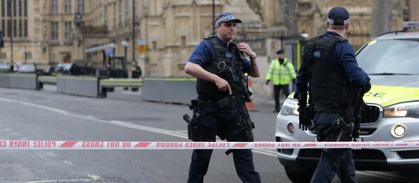 Armed police officers guard at a police cordon outside the Houses of Parliament in central London on March 22, 2017 during an emergency incident - Sputnik International