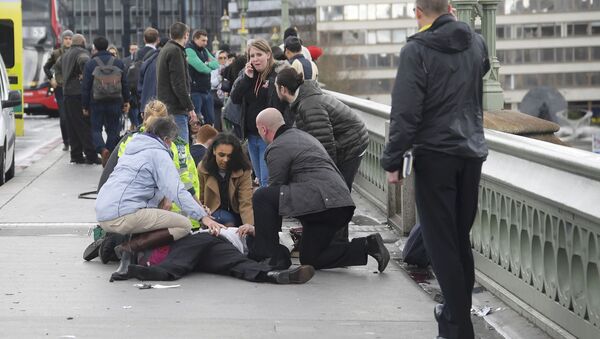 Injured people are assisted after an incident on Westminster Bridge in London - Sputnik International