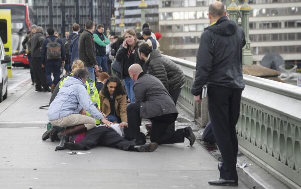 Injured people are assisted after an incident on Westminster Bridge in London - Sputnik International