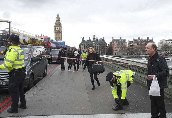 A woman ducks under a police tape after an incident on Westminster Bridge in London A woman ducks under a police tape after an incident on Westminster Bridge in London - Sputnik International