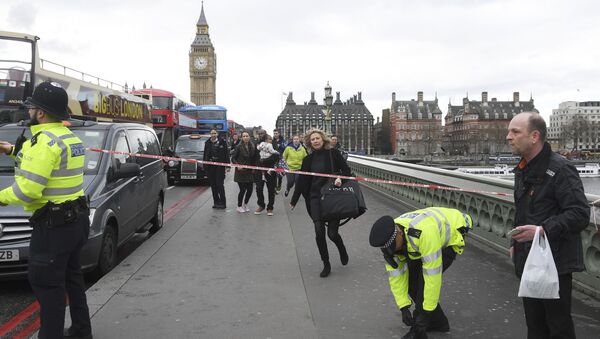 A woman ducks under a police tape after an incident on Westminster Bridge in London - Sputnik International