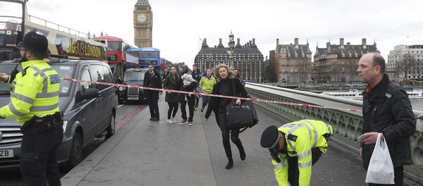 A woman ducks under a police tape after an incident on Westminster Bridge in London - Sputnik International