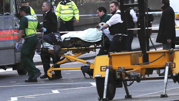 Members of the emergency services take an injured person away on a stretcher after an incident on Westminster Bridge in London, Britain - Sputnik International