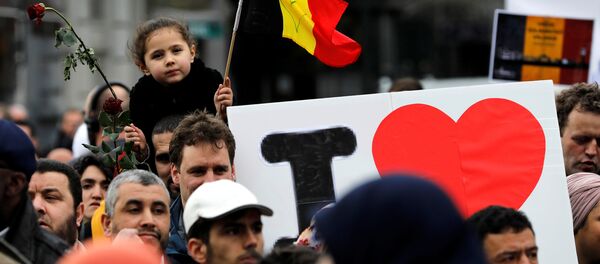 People take part in a march in front of the Brussels Stock Exchange, La Bourse, as part of ceremonies commemorating the first anniversary of twin attacks at Brussels airport and a metro train, Belgium, March 22, 2017. - Sputnik International