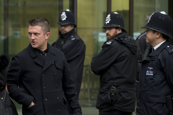 Tommy Robinson, left, the former leader of the far-right EDL English Defence League group walks past police officers as he leaves after an appearance at Westminster Magistrates Court in London, Wednesday, Oct. 16, 2013. Tommy Robinson, left, the former leader of the far-right EDL English Defence League group walks past police officers as he leaves after an appearance at Westminster Magistrates Court in London, Wednesday, Oct. 16, 2013. - Sputnik International