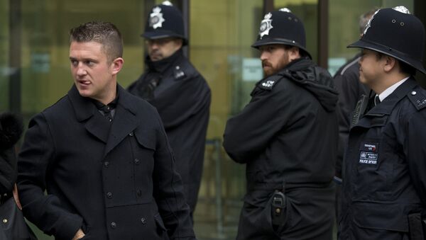 Tommy Robinson, left, the former leader of the far-right EDL English Defence League group walks past police officers as he leaves after an appearance at Westminster Magistrates Court in London, Wednesday, Oct. 16, 2013. - Sputnik International