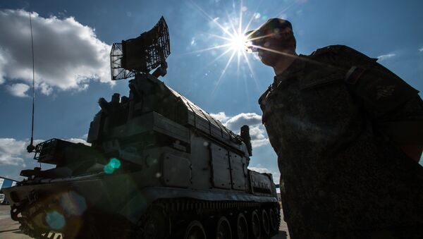A serviceman is seen near a Tor surface-to-air missile system during preparations for the Engineering Technologies 2014 international forum in Zhukovsky near Moscow - Sputnik International