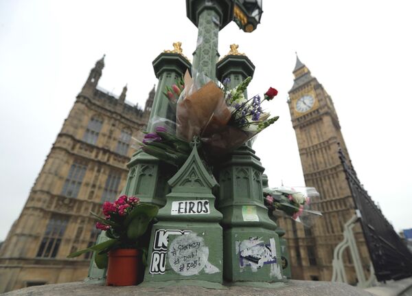 Floral tributes to victims of Wednesday's attack are tied to a lamppost outside the Houses of Parliament in London, Friday March 24, 2017.  - Sputnik International