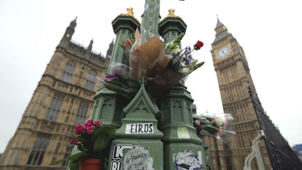 Floral tributes to victims of Wednesday's attack are tied to a lamppost outside the Houses of Parliament in London, Friday March 24, 2017. - Sputnik International