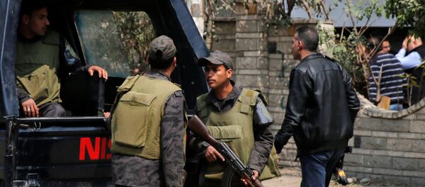 Riot police officers stand guard in front of the wall of a property's garden as security officials inspect the scene of an explosion, where the Interior Ministry said an unidentified metallic object was found, in the Cairo suburb of Maadi, Egypt, March 24, 2017 - Sputnik International