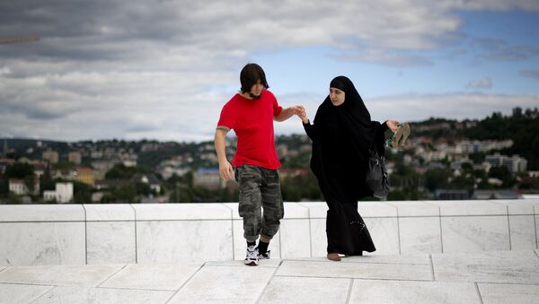 A man helps a woman up a step on the roof of the Opera house in Oslo on August 11 , 2011 - Sputnik International
