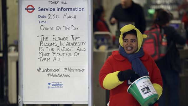 A woman collecting money for charity stands next to a quote written on an information board at Tower Hill underground train station, written in defiance of the previous day's attack in London, Thursday, March 23, 2017. - Sputnik International