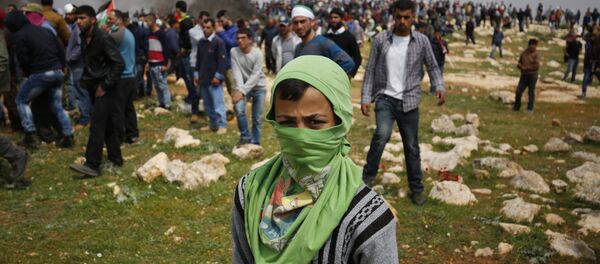 A young Palestinian protestor poses for a photo during clashes with Israeli security forces following a demonstration against Jewish settlements in village of al-Mughayyir, near the West Bank city of Ramallah, on March 24, 2017 A young Palestinian protestor poses for a photo during clashes with Israeli security forces following a demonstration against Jewish settlements in village of al-Mughayyir, near the West Bank city of Ramallah, on March 24, 2017 - Sputnik International