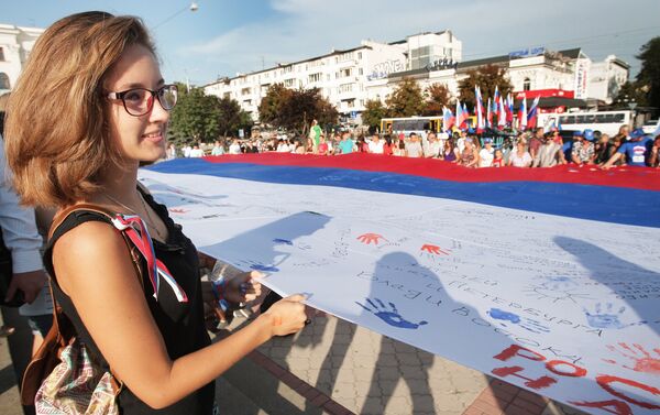 Simferopol residents during the Russian Flag Day celebrations in Crimea. A 162 sq m Russian flag has been spread on the central square in the Crimean capital - Sputnik International