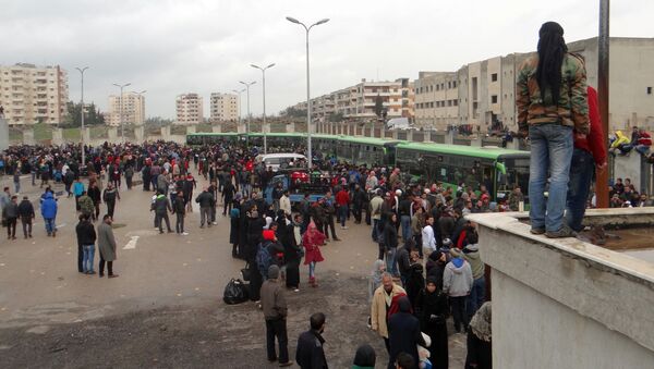 Opposition fighters and their families gather as they prepare to board a bus, ahead of their evacuation from the rebel-held Waer neighbourhood in the central city of Homs on March 18, 2017 - Sputnik International