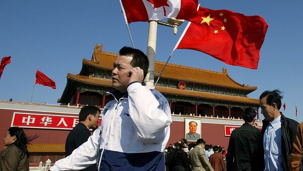A man walks past flags of Canada and China in front of Tiananmen Gate in Beijing (File) - Sputnik International