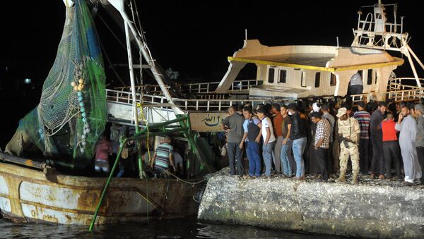 This file photo taken on September 28, 2016 shows people gathering on the quay as a wreck of a migrant boat raised by the Egyptian navy and maritime rescuers arrives in the Egyptian port city of Rosetta. An Egyptian court on March 26, 2017 sentenced 56 people to prison terms of between seven and 10 years over the deaths at sea of at least 202 migrants in September, judicial officials said - Sputnik International