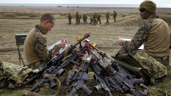 US Marines sit by a pile of assault rifles - Sputnik International